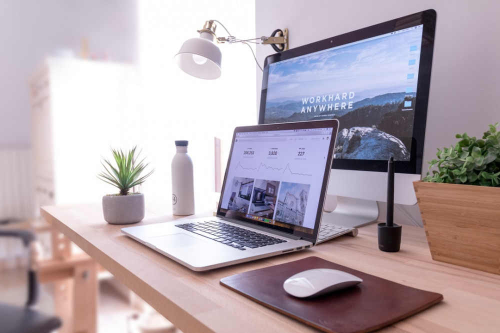 image of computers on a desk, with a website on the screen